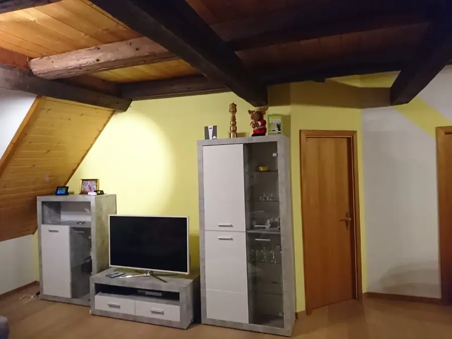 Dachzimmer mit Holzbalken und frisch gestrichenen Wänden
